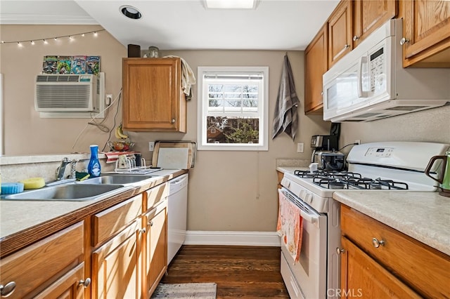 kitchen with white appliances, dark wood-style flooring, a sink, baseboards, and light countertops