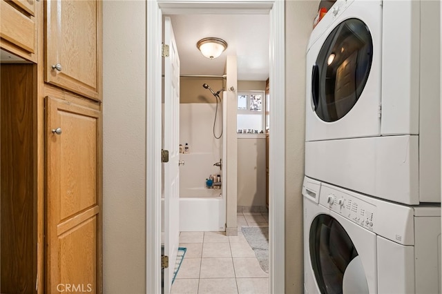 laundry room featuring light tile patterned floors, laundry area, and stacked washer / dryer