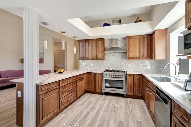 1268 Via, San Jacinto, San Marcos, CA 92078 - kitchen featuring brown cabinets, appliances with stainless steel finishes, light wood-style flooring, light stone counters, and decorative backsplash