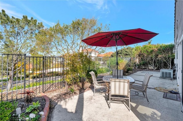 view of patio / terrace with outdoor dining area, central AC, and fence