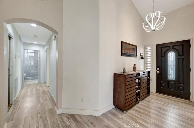 1268 Via, San Jacinto, San Marcos, CA 92078 - foyer entrance featuring arched walkways, light wood-type flooring, high vaulted ceiling, and a chandelier