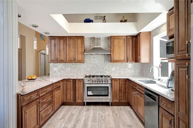1268 Via, San Jacinto, San Marcos, CA 92078 - kitchen featuring brown cabinets, stainless steel appliances, light wood-style floors, and wall chimney exhaust hood