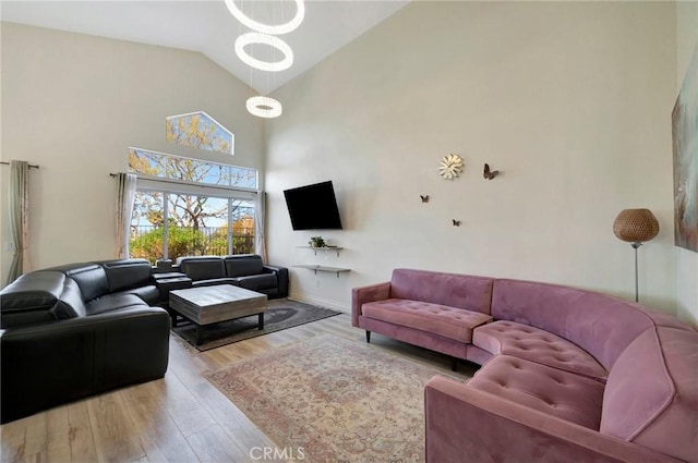 living room with high vaulted ceiling and wood finished floors