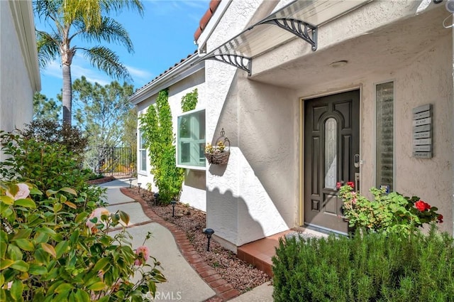 doorway to property featuring stucco siding