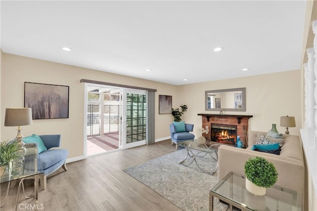 living room with a fireplace, baseboards, wood finished floors, and recessed lighting