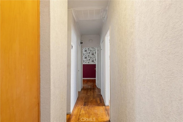 hall with a textured wall and wood finished floors