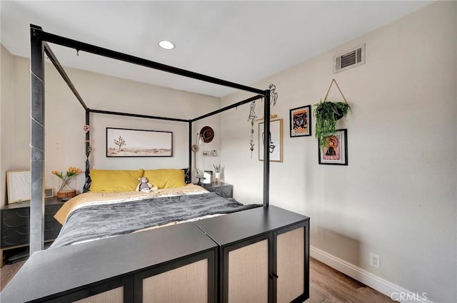 bedroom with recessed lighting, wood finished floors, visible vents, and baseboards