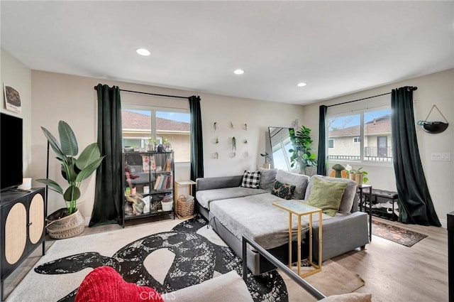 living area with recessed lighting, a wealth of natural light, and wood finished floors