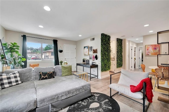 living room with light wood-style floors, baseboards, visible vents, and recessed lighting