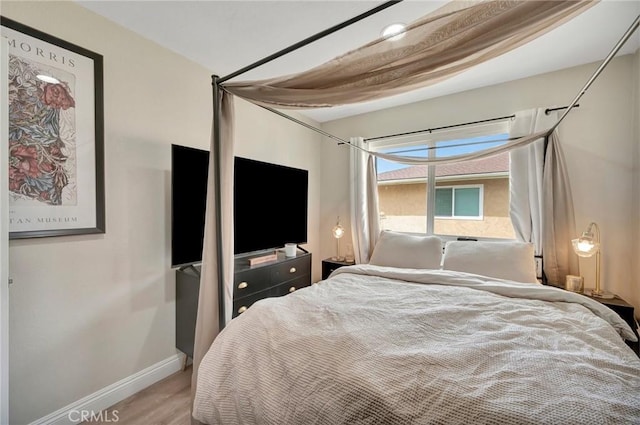 bedroom with baseboards and wood finished floors