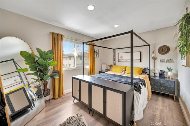 bedroom featuring baseboards, wood finished floors, and recessed lighting