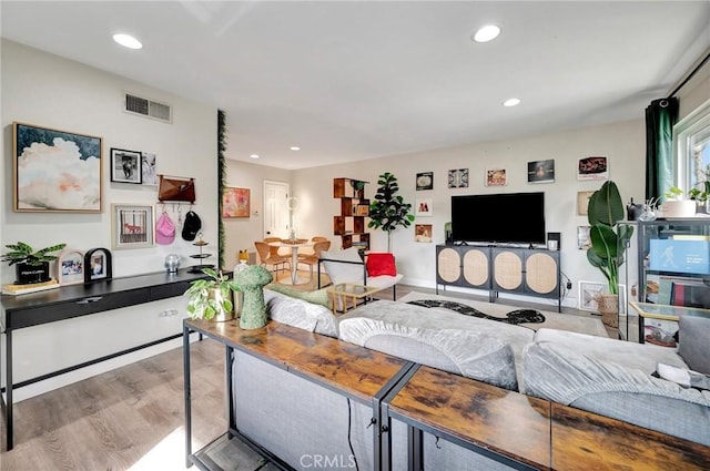 living area with wood finished floors, visible vents, and recessed lighting