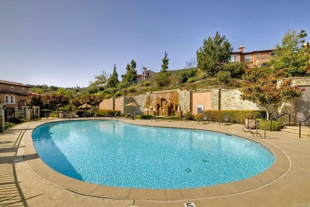 community pool featuring a patio area and fence