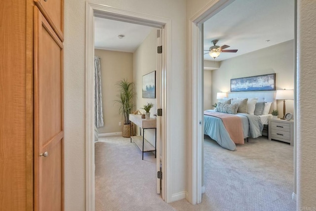 bedroom with light colored carpet, ceiling fan, and baseboards