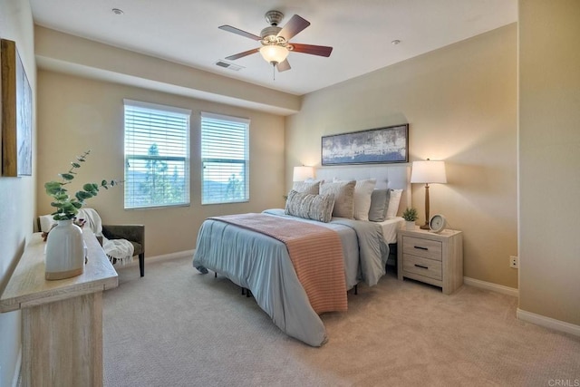 bedroom featuring a ceiling fan, light colored carpet, visible vents, and baseboards