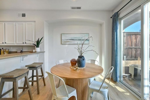 dining space featuring visible vents and light wood finished floors