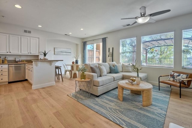 living area with baseboards, recessed lighting, visible vents, and light wood-style floors