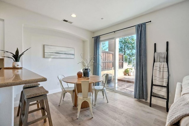 dining room with recessed lighting, baseboards, visible vents, and light wood finished floors