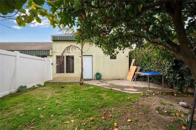 back of house with a patio area, a yard, fence, and stucco siding