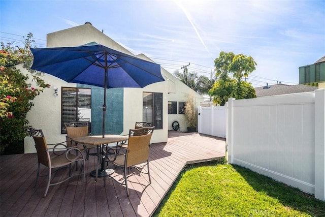 wooden terrace with outdoor dining space and fence