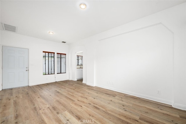 empty room with baseboards, visible vents, and light wood-style floors