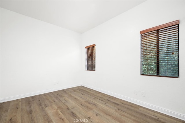 unfurnished room featuring baseboards and wood finished floors