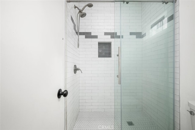 bathroom with toilet and a shower stall