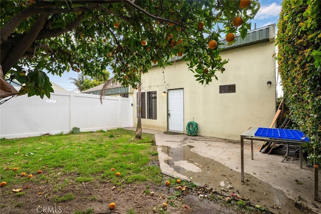 back of property featuring a yard, fence, a patio, and stucco siding