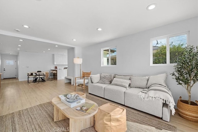 living area with light wood-style floors, a wealth of natural light, and recessed lighting