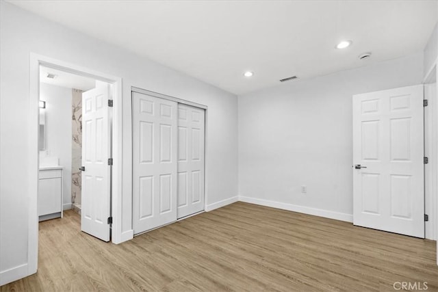 unfurnished bedroom featuring light wood finished floors, visible vents, baseboards, a closet, and recessed lighting