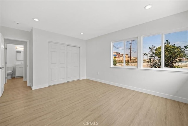 unfurnished bedroom featuring baseboards, recessed lighting, and light wood-style floors