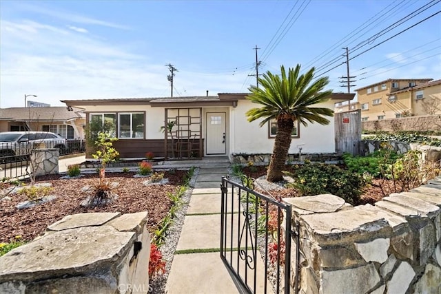 view of front of property featuring a fenced front yard and stucco siding