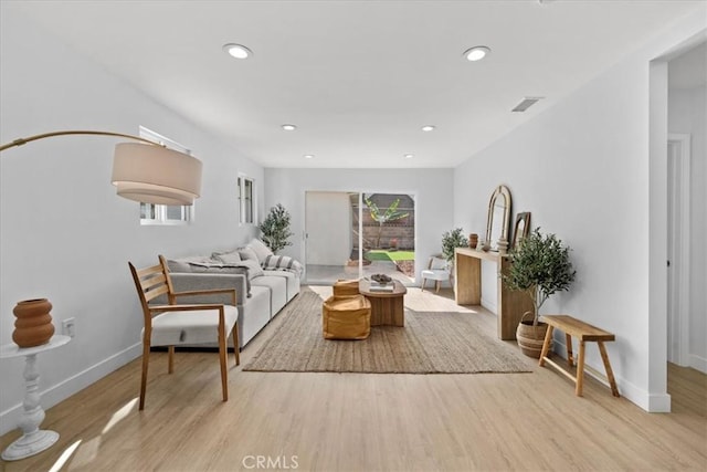 living area featuring visible vents, baseboards, light wood-style flooring, and recessed lighting