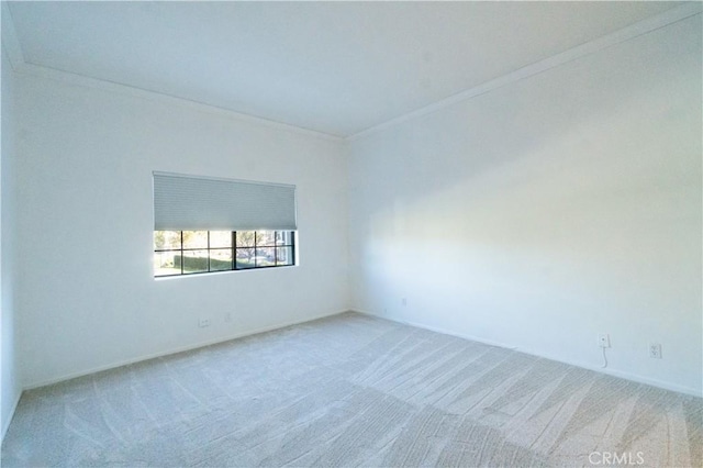 carpeted spare room featuring crown molding