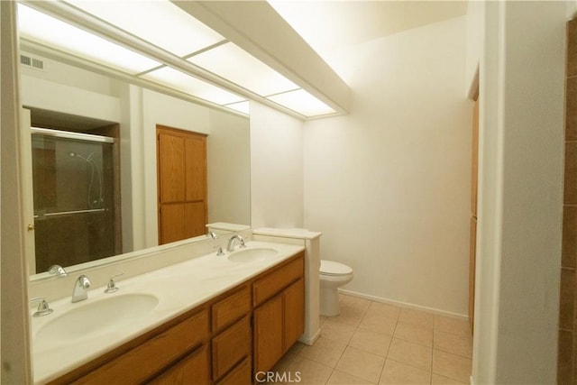 full bath featuring a sink, a shower stall, toilet, and double vanity