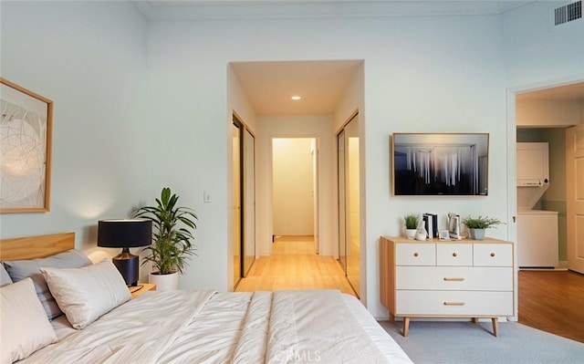 20271 Sealpoint Unit 104, Huntington Beach, CA 92646 - bedroom with stacked washer / dryer, light wood-style flooring, visible vents, recessed lighting, and ensuite bath