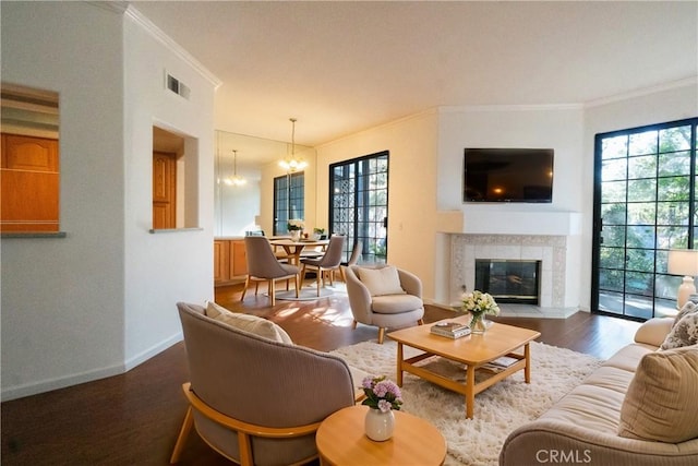 20271 Sealpoint Unit 104, Huntington Beach, CA 92646 - living room featuring a chandelier, ornamental molding, a wealth of natural light, and wood finished floors