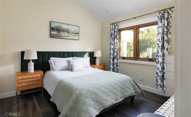 bedroom with lofted ceiling, baseboards, and wood finished floors