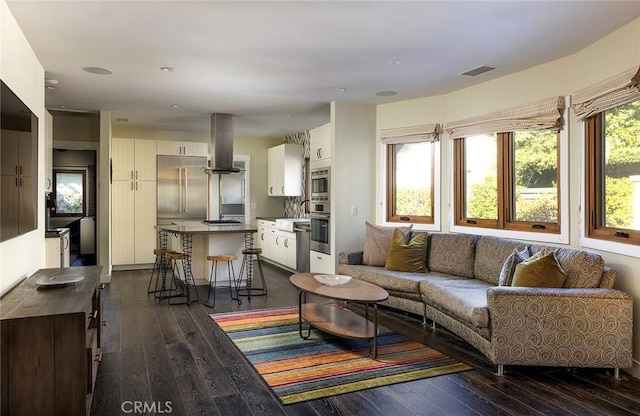 living room with dark wood-type flooring and visible vents