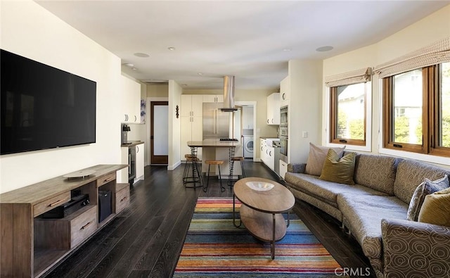 living area featuring dark wood-style floors and washer / clothes dryer