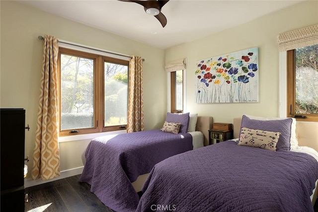 bedroom with baseboards, multiple windows, a ceiling fan, and dark wood-type flooring