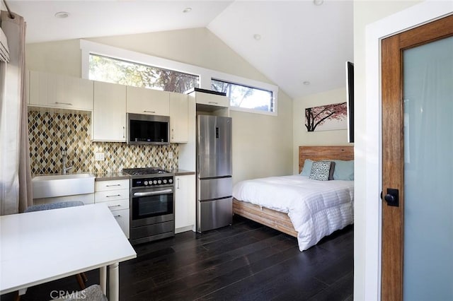 bedroom featuring freestanding refrigerator, dark wood finished floors, a sink, and lofted ceiling