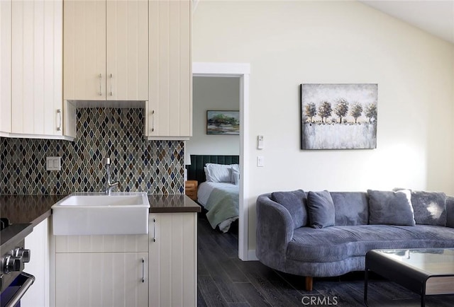 kitchen featuring open floor plan, dark countertops, and white cabinetry