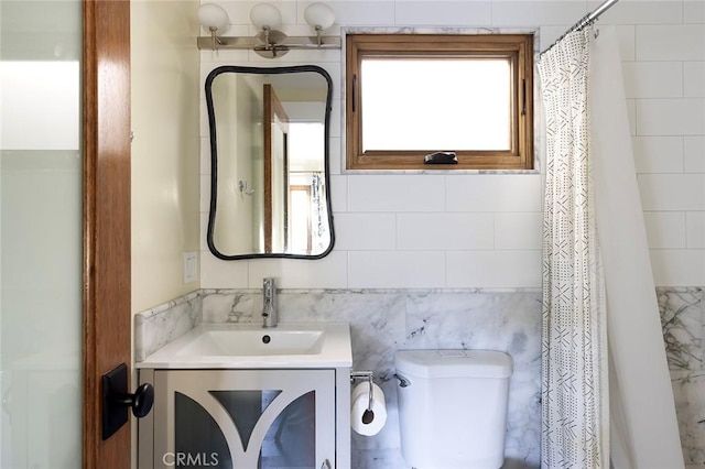 bathroom featuring a shower with curtain, tile walls, toilet, and vanity