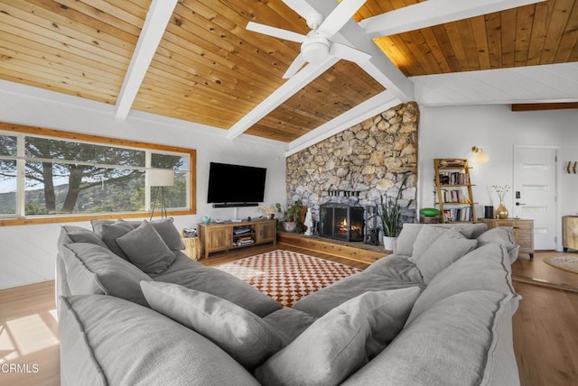 living room featuring lofted ceiling with beams, wooden ceiling, ceiling fan, wood finished floors, and a fireplace