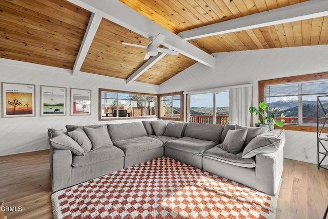 living area featuring lofted ceiling with beams, wooden ceiling, a ceiling fan, and wood finished floors