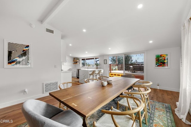 dining area with visible vents, recessed lighting, light wood-style flooring, and vaulted ceiling with beams