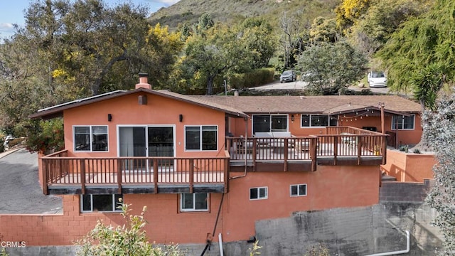 rear view of property featuring a deck