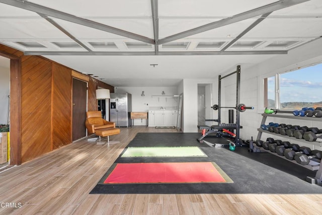 exercise area featuring wood walls and wood tiled floor