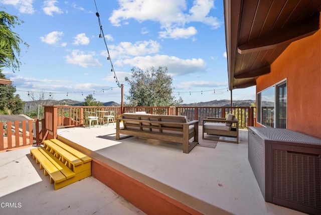 wooden deck featuring an outdoor hangout area and a mountain view